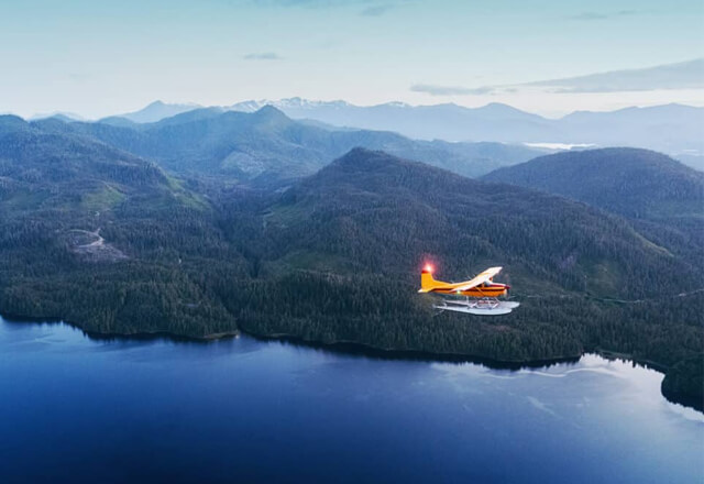 Fliegendes Wasserflugzeug über einen Bergsee